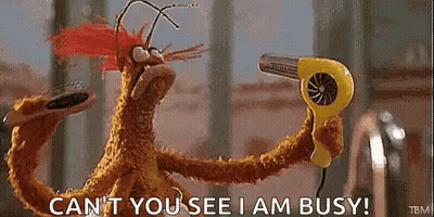 A Stuffed Animal Is Holding A Yellow Hair Dryer And Saying `` Can 'T You See I Am Busy '' . GIF