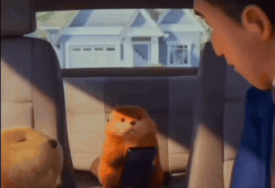 A Stuffed Animal Is Sitting In The Back Seat Of A Car With A Man Looking At It GIF