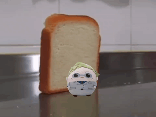 A Stuffed Animal Is Standing In Front Of A Loaf Of Bread GIF