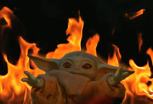 A Stuffed Animal Is Standing In Front Of A Wall Of Fire GIF