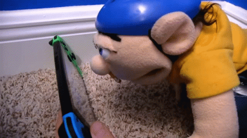 A Stuffed Animal Laying On The Floor Looking At A Nintendo Switch GIF