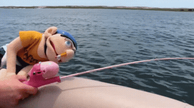 A Stuffed Animal On A Boat With A Fishing Rod And A Cigarette In Its Mouth GIF