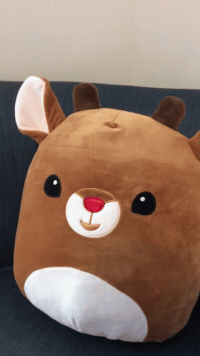 A Stuffed Animal That Looks Like A Reindeer With A Red Nose GIF
