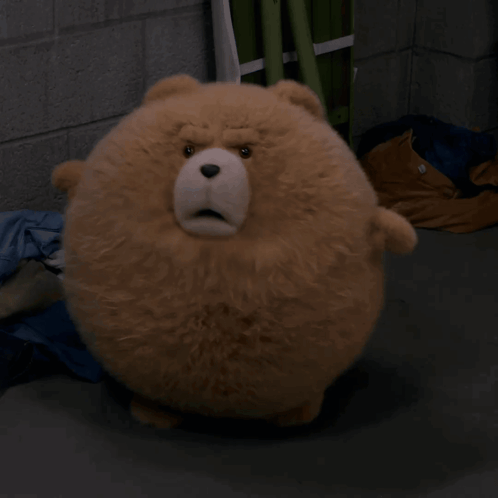 A Stuffed Animal That Looks Like A Teddy Bear Is Sitting On The Ground GIF