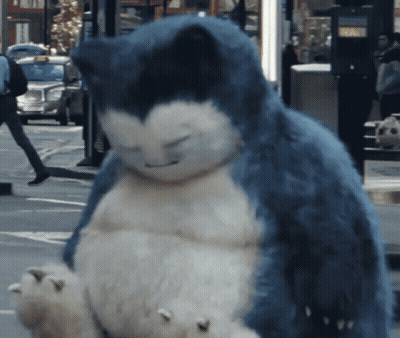 A Stuffed Animal That Looks Like Snorlax Is Sitting On The Sidewalk GIF