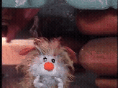 A Stuffed Animal With A Carrot On Its Nose Is Being Held By A Person GIF