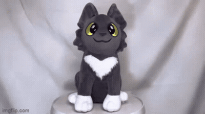 A Stuffed Animal With A Heart On Its Chest Is Sitting On Top Of A Table . GIF