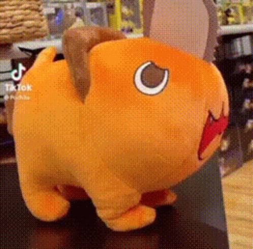 A Stuffed Animal With A Red Mouth Is Sitting On A Table . GIF