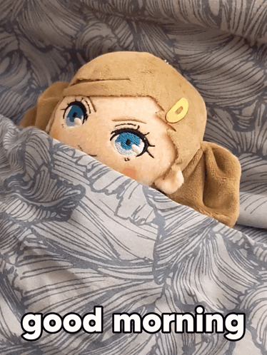 A Stuffed Animal With Blue Eyes Is Laying Under A Blanket With The Words Good Morning Below It GIF
