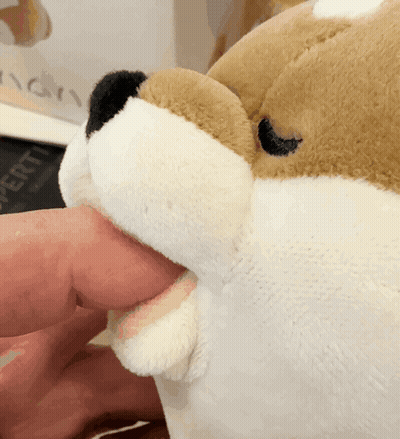 A Stuffed Animal With Its Mouth Open Is Being Held By A Hand GIF