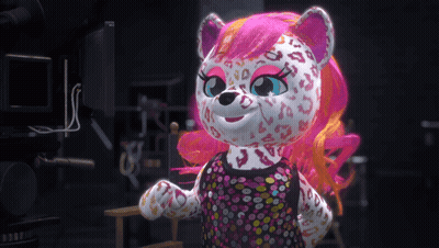 A Stuffed Animal With Pink Hair And A Leopard Print Is Standing In Front Of A Camera GIF