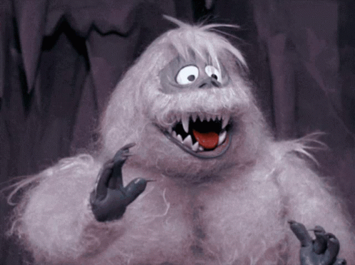 A Stuffed Animal With Sharp Teeth And A Tongue Out GIF