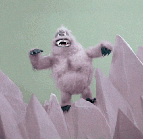 A Stuffed Animal With Sharp Teeth Is Standing On Top Of A Pile Of Ice GIF