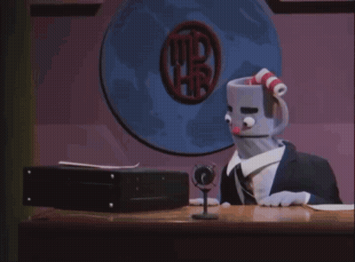 A Stuffed Cuphead Is Sitting At A Desk In Front Of A Computer Screen GIF