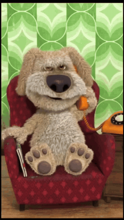 A Stuffed Dog Is Sitting In A Red Chair Talking On A Phone GIF