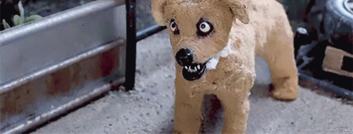 A Stuffed Dog With A Collar And A Black Mouth Is Standing On The Ground . GIF