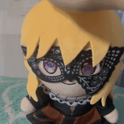 A Stuffed Doll Wearing A Mask And A Necklace GIF