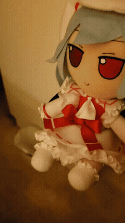 A Stuffed Doll With Blue Hair And A Red Bow GIF