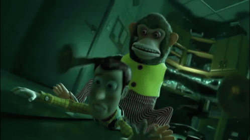 A Stuffed Monkey Is Holding Buzz Lightyear In A Room . GIF
