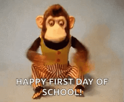 A Stuffed Monkey Is Sitting Down With The Words `` Happy First Day Of School '' Written On It . GIF