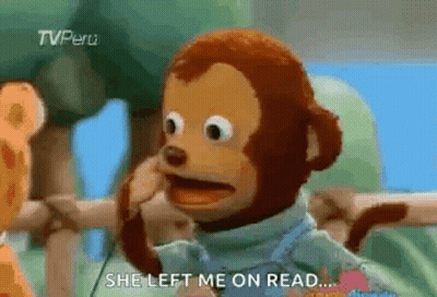 A Stuffed Monkey Is Talking On A Cell Phone While Standing Next To A Giraffe . GIF