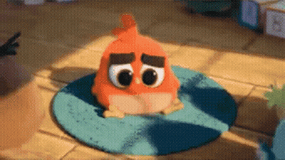 A Stuffed Orange Bird Is Sitting On A Blue Rug On The Floor . GIF