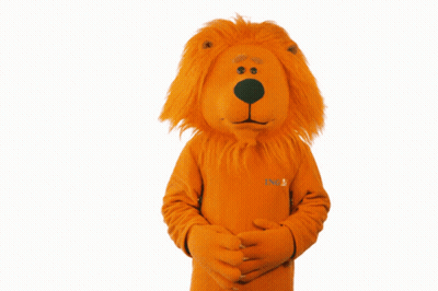 A Stuffed Orange Lion Mascot With The Word Lions On The Front GIF