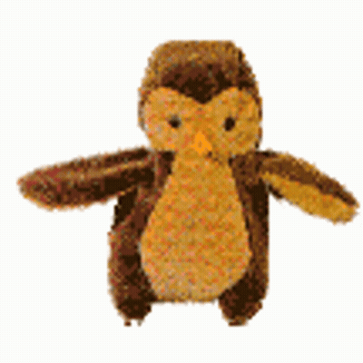 A Stuffed Owl With Wings Is Sitting On A White Surface . GIF