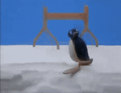A Stuffed Penguin Is Crawling On A White Surface . GIF