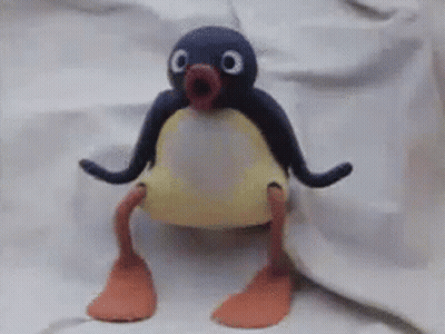 A Stuffed Penguin Is Sitting On A White Cloth GIF