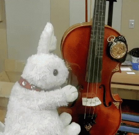 A Stuffed Rabbit Playing A Violin With A Clock Attached To It GIF