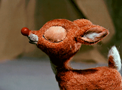 A Stuffed Reindeer With A Red Nose And A White Tail GIF