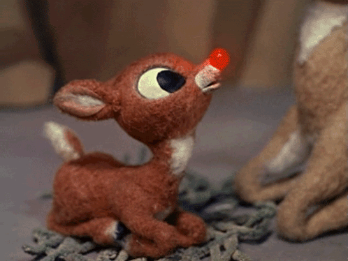 A Stuffed Reindeer With A Red Nose Looks Up GIF