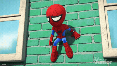 A Stuffed Spider Man Is Hanging On A Green Brick Wall From Disney Junior GIF