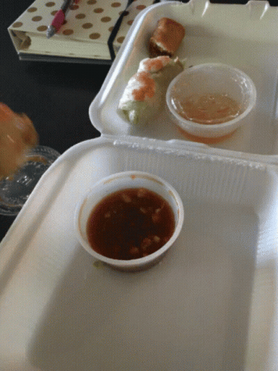 A Styrofoam Container Filled With Food And Dipping Sauces GIF