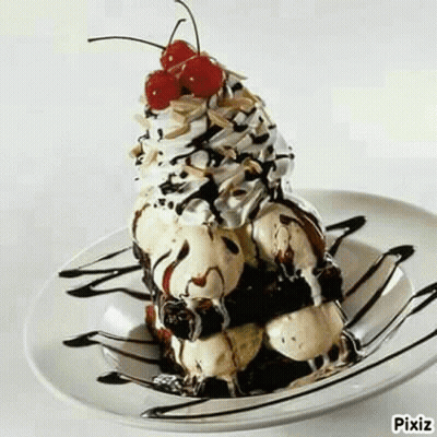 A Sundae With Ice Cream , Chocolate Sauce , Whipped Cream And A Cherry On Top On A Plate . GIF