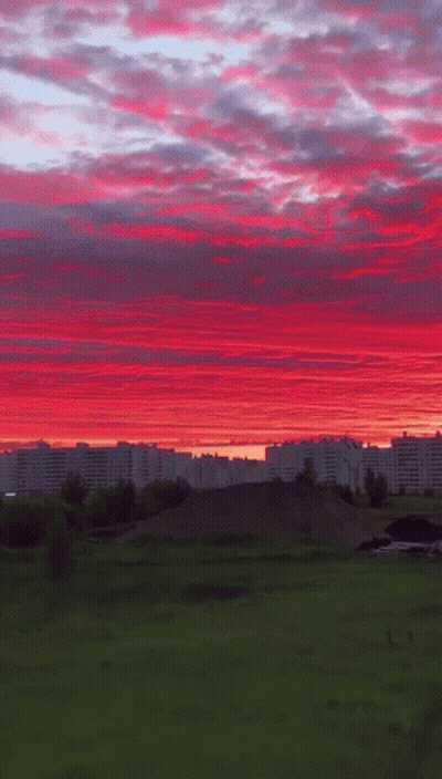 A Sunset Over A City With Buildings In The Distance GIF