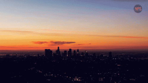 A Sunset Over A City With The Letters Nps On The Bottom Right GIF