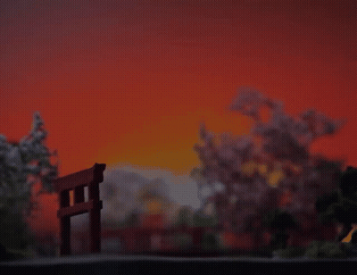 A Sunset With A Torii Gate In The Foreground And Cherry Blossom Trees In The Background GIF