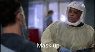 A Surgeon Wearing A Helmet And Gloves Is Talking To Another Surgeon . GIF