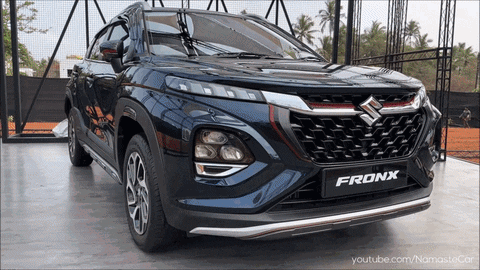A Suzuki Fronx Is Parked In Front Of A Fence GIF
