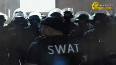 A Swat Officer Stands In Front Of A Crowd Of Police GIF