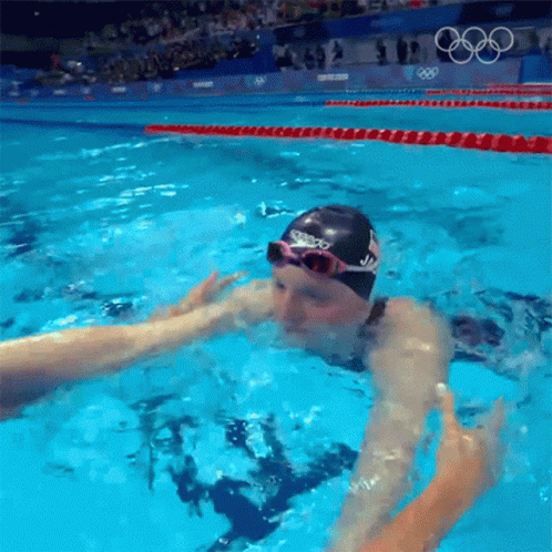 A Swimmer Wearing A Speedo Swim Cap And Goggles GIF