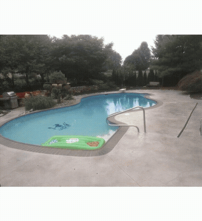 A Swimming Pool With A Green Raft In The Middle Of It GIF
