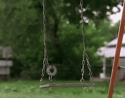 A Swing Is Hanging From Chains In The Grass GIF
