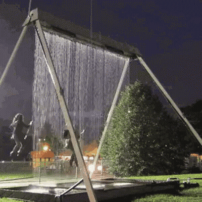A Swing Set With A Waterfall In The Background GIF