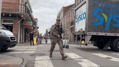 A Sysco Truck Is Driving Down A Busy Street GIF