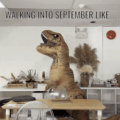 A T-Rex In An Office With The Words Walking Into September Like GIF
