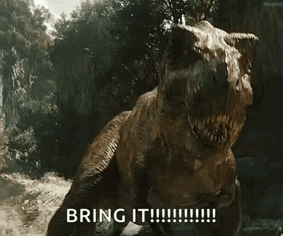 A T-Rex Says " Bring It " In Front Of A Cliff GIF
