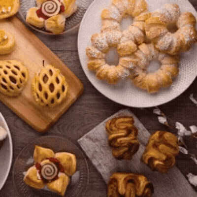A Table Topped With A Variety Of Pastries And Cakes . GIF